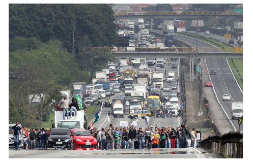 Rodovia paralisada por uma centena de manifestantes.